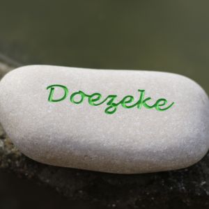 Een steentje met de naam van een huisdier gegraveerd in een mooie kleur groen ingekleurd in een licht keitje.